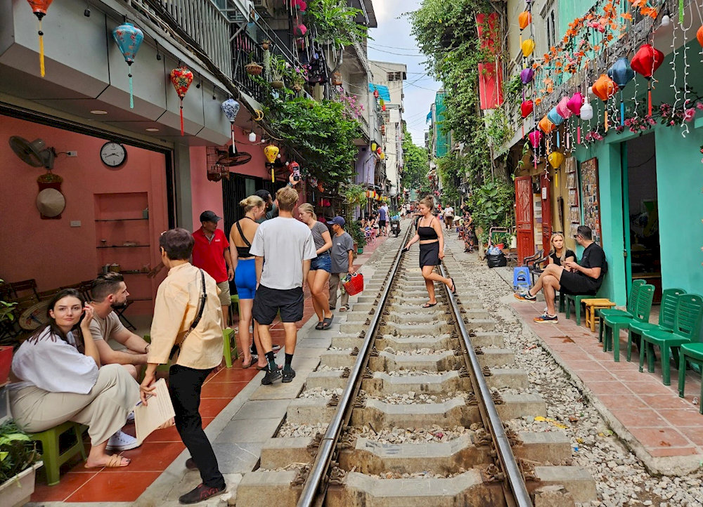Tourists are thrilled by the image of trains running through Hanoi's Train Street 